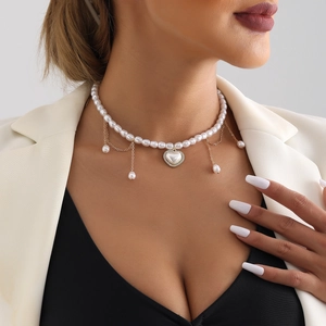 Elegante parelketting met een fonkelende hartvormige hanger en fijne kwastjesdetails