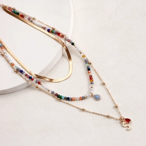 Dettaglio della collana multistrato boho con perline colorate e ciondoli dorati