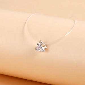 Detailed close-up of a minimalist invisible necklace featuring a triangular zircon pendant