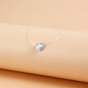 Detailed macro view of heart-shaped zircon pendant on invisible fish line necklace