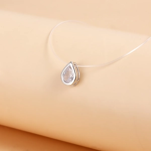 Detailed view of teardrop zircon pendant on invisible crystal thread necklace
