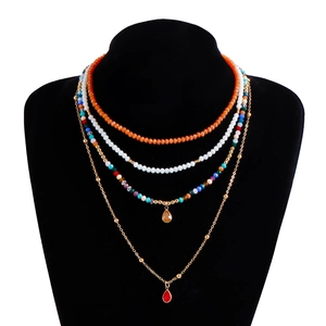 Dettaglio di una collana boho a quattro strati con perline colorate e ciondoli a goccia