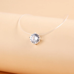 Macro shot of clear zircon pendant on invisible fish line string with four-prong setting