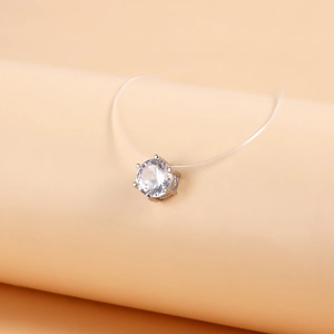 Macro shot of single round zircon pendant with six-prong setting on invisible nylon line