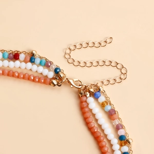 Dettaglio di collana bohémien multistrato con perline colorate e chiusura a moschettone