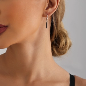 Gros plan de boucles d'oreilles argentées minimalistes avec long pendentif rectangulaire