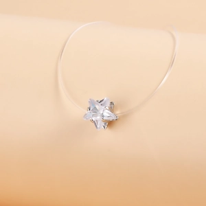 Detailed macro view of a star-shaped zircon pendant on an invisible fishing line necklace
