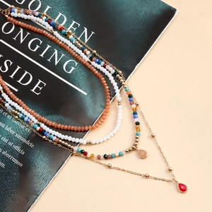 Dettaglio della collana boho a più strati con perline colorate e ciondoli a goccia