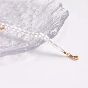Detail van parelketting met gepolijste gouden karabijnsluiting en gladde textuur
