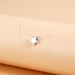 Macro shot of silver star pendant on clear invisible fishing line necklace