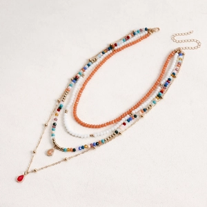 Dettaglio della collana bohémien a strati con perle colorate e pendenti a goccia rossa