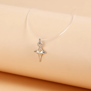 Detail of silver star pendant on a minimalist transparent fishing line necklace for women