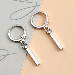 Gros plan de boucles d'oreilles géométriques en argent avec pendentifs barre