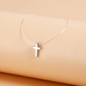 Detail of silver cross pendant on invisible fishing line necklace with mirror finish