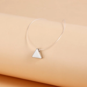 Close-up of minimalist silver triangle pendant on transparent floating fishing line