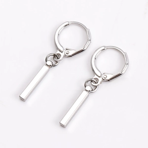 Vue detaillee de boucles d oreilles argentee avec pendentif barre longue et creoles huggie