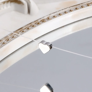 Macro shot of a silver heart-shaped pendant on transparent line against relief background