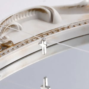 Detailed close-up of polished silver cross pendant on invisible line with mirror reflection