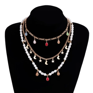 Dettaglio della collana boho a strati con ciondoli a goccia colorati e perle