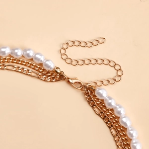 Primo piano della collana multistrato dorata con chiusura a moschettone e catenella
