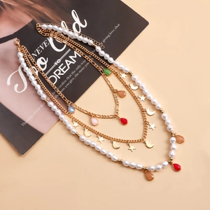 Dettaglio della collana boho multistrato con perle, ciondoli stella luna e gocce colorate