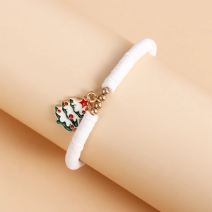 Detailed macro shot of a white Heishi bead bracelet with a green enamel Christmas tree charm
