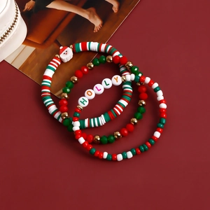 Detailed view of festive Christmas beaded bracelets with Santa charms and Holly letter beads