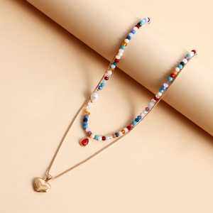 Dettaglio della collana bohémien a strati con perline colorate e ciondolo a cuore
