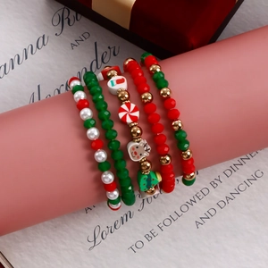 5-piece set of Christmas beaded bracelets with Santa and reindeer charms on pink stand