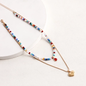 Dettaglio di perline colorate, perla bianca e pendente a goccia rossa su collana