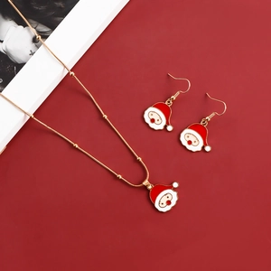 Close-up of Santa Claus pendant necklace and earring set with red and gold enamel details