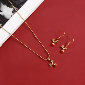 Close-up of golden reindeer necklace and earrings set with red and green enamel details