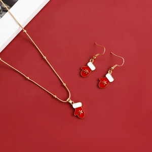 Detail of Christmas jewelry set with red glove pendants and golden snowflake patterns