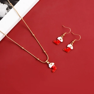 Detail of Christmas stocking necklace and hook earrings set with golden snowflake motifs