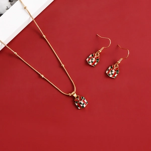Macro detail of Christmas gift box jewelry set with red enamel and gold beaded chain
