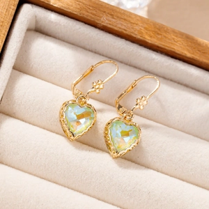 Detail of gold heart pendant earrings with iridescent green crystal in a velvet box