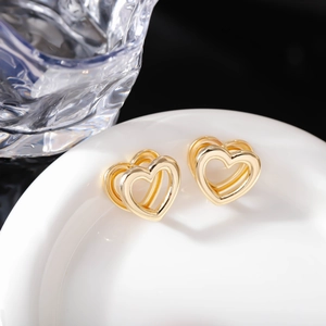 Vista dettagliata di orecchini a cuore dorati con un design geometrico 3D multistrato