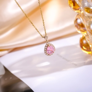 Detail of water drop pendant with pink zircon and white pavé crystals on gold chain