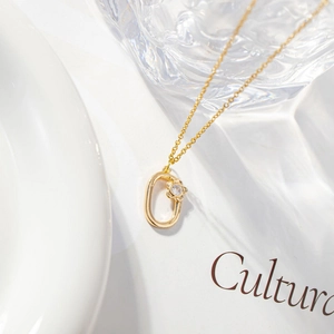 Minimalist gold necklace featuring a zircon-inlaid oval floral pendant on a fine link chain