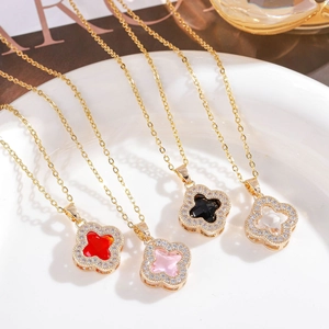 Detailed view of four-leaf clover necklaces in multiple colors on a porcelain plate