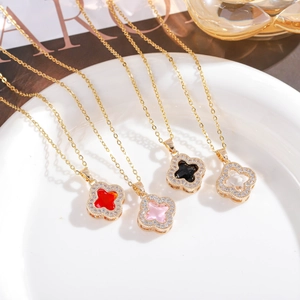 Close-up of four-leaf clover necklaces in red, pink, and black with gold chains