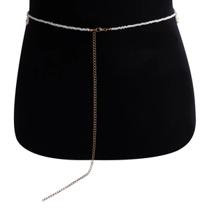 Gros plan d'une chaîne de taille en perles blanches avec extension dorée sur un mannequin