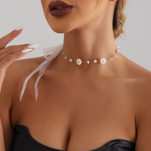 Elegante goldene Halskette mit Gänseblümchen-Anhängern und Perlen an einem weiblichen Model