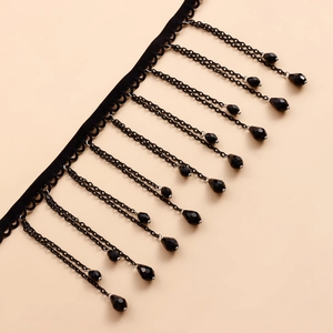 Detalle del choker gótico de terciopelo negro con cadenas de borlas y cuentas de gota