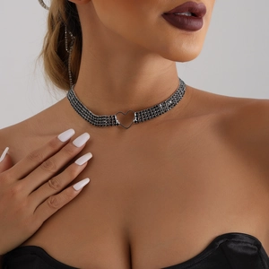 Nahaufnahme eines schwarzen mehrlagigen Strass-Chokers mit hohlem Herz-Anhänger