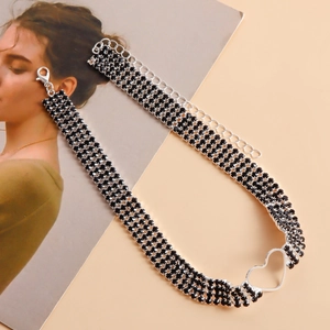 Detailaufnahme eines dreireihigen schwarzen Strass-Chokers mit silbernem Herz-Anhänger