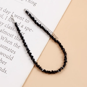 Detail van zwarte kristallen kralenketting met zilveren karabijnsluiting en verlengketting