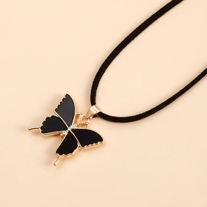 Détail du pendentif papillon noir aux bords dorés avec cordon en velours réglable