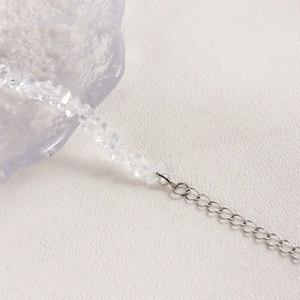 Macro-detail van gefacetteerde kristallen kralen en zilveren verlengketting aan ketting
