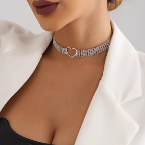 Macro detail of triple-layer rhinestone choker featuring a hollow heart pendant
